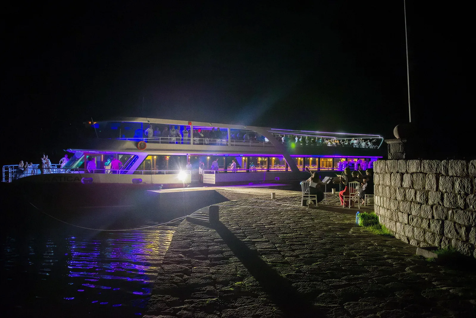 Katica lit up at night alongside the quay on the Pine promenade in Tivat